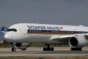 Singapore Airlines' profit nearly halves, causing shares to fall 6% amid intensifying competition.