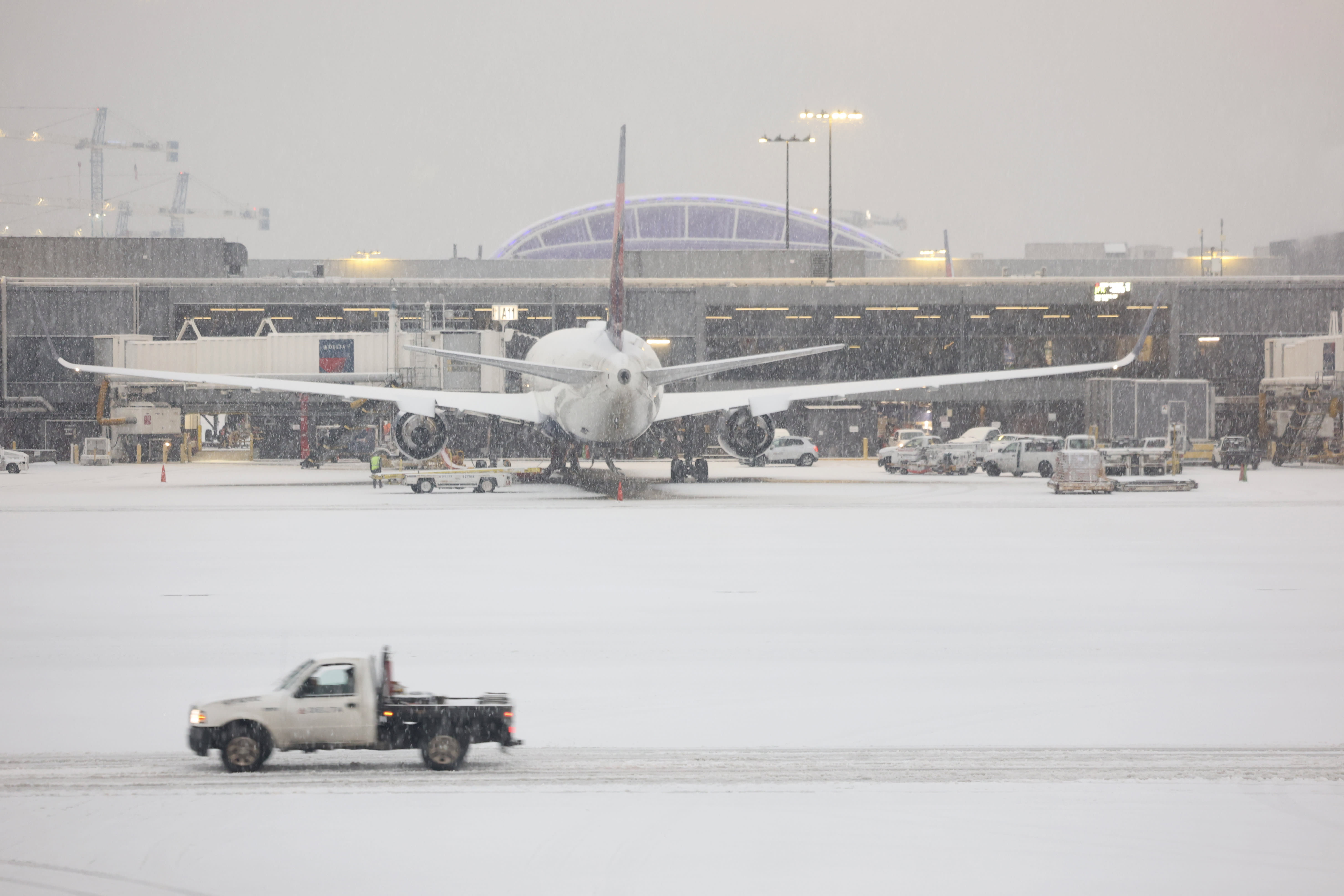 Over 2,000 U.S. flights are canceled due to the storm, and Delta experiences a slide-evacuation at Atlanta.