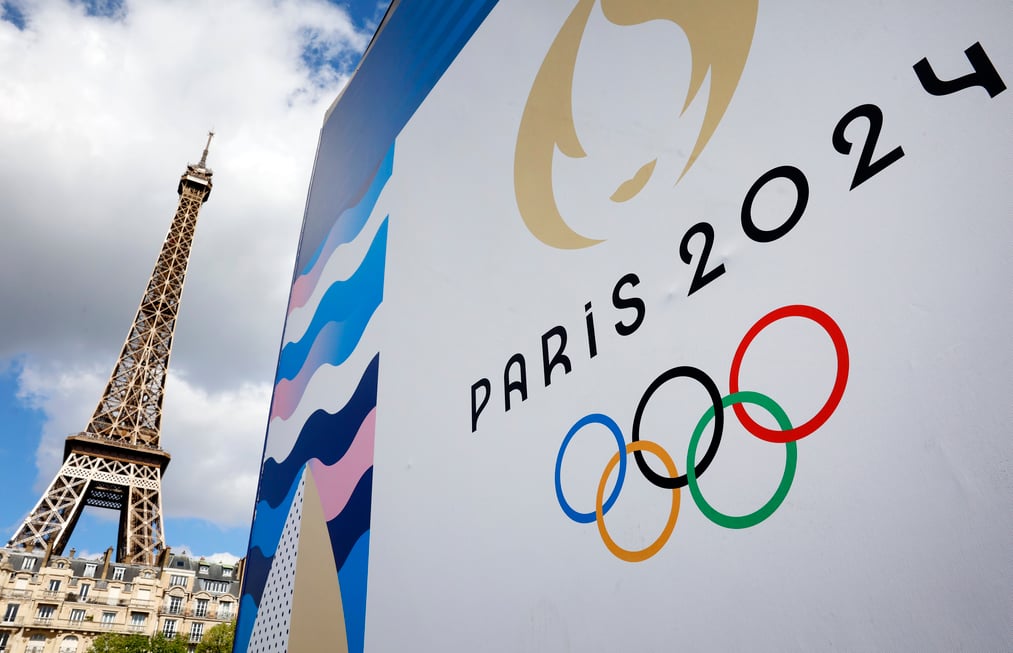 What factors contributed to the lower cost of the Paris Olympics compared to previous host cities such as Rio, London, and Tokyo?
