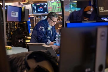 Traders evaluate the economic climate after Moody's cuts its U.S. outlook, resulting in an increase in treasury yields.